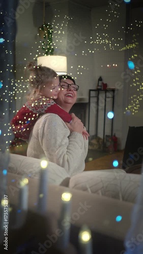 Warm family evening at home in Finland. Grandmother and grandson in cozy sweaters enjoying winter lights and Christmas mood, sharing stories and love in soft candlelight.