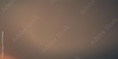 Soft focus sun setting over the ocean glowing orange with dark blue background disign