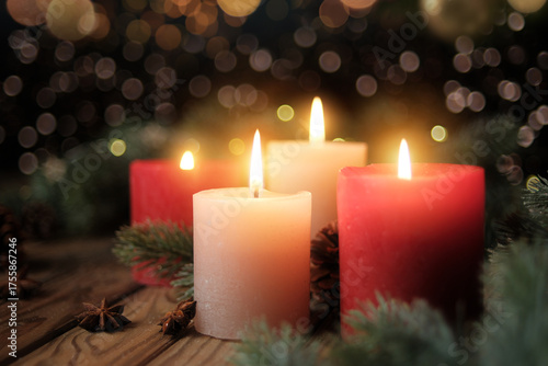 Four burning candles with dark blurred background. Tranquil Christmas mood with Advent candleflames, fir branches and lights