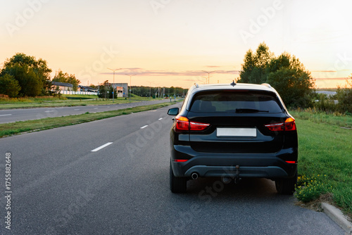A black car is parked on the side of the road.