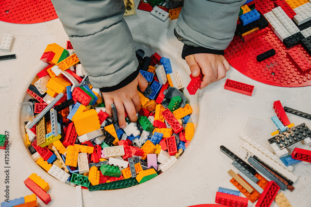 Obraz premium Prague, Czechia - September 20, 2025: Child hand playing with colorful Lego bricks