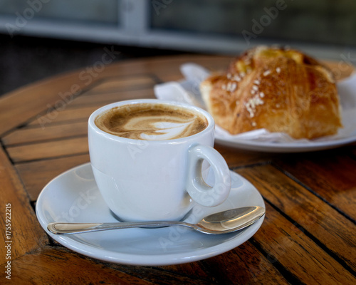 White coffee cup with a spoon on a wooden table