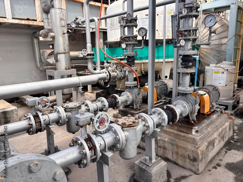 Industrial pumping system with corroded steel pipes, flanges, and gate valves showing rust damage and a need for urgent maintenance. The complex network is typical of a cooling or water treatment plan