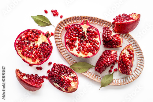 Top view of fresh ripe pomegranate and pieces on plate for eating, top view.