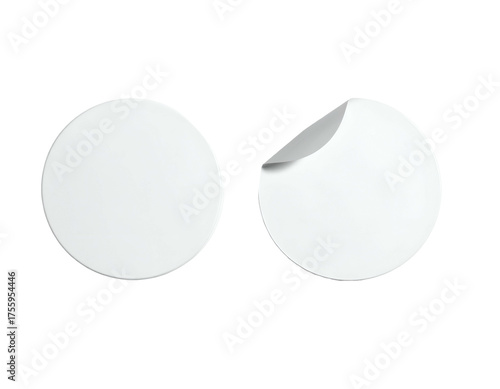 Two white, round stickers isolated on a black background; one with a corner peeling