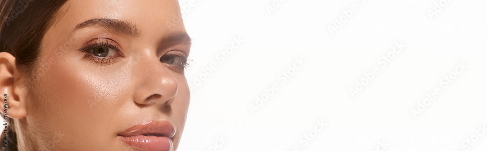 Obraz premium Stunning young woman with natural makeup against a bright white backdrop