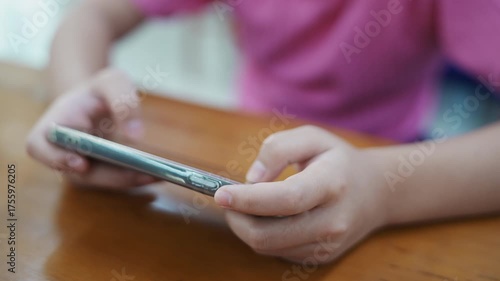 Closeup girl hands using smartphone to text the message or playing online game on her phone. Concept of digital addiction. Digitalization and informatization of society in modern world.