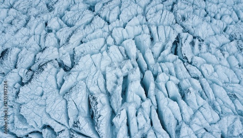 Aerial close-up of icy glacier surface showcasing abstract patterns and natural textures in a winter landscape