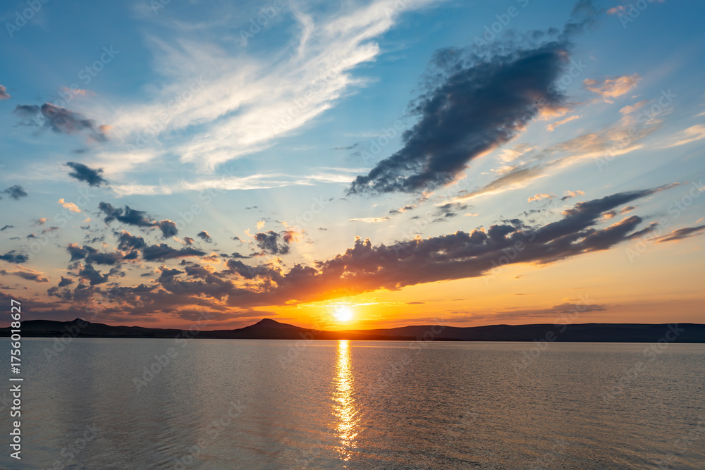 Fototapeta premium A colorful sunset over a lake among the clouds.