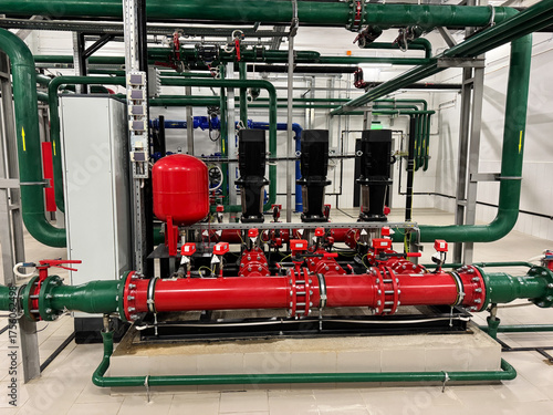 Industrial boiler plant, heating system. System is equipped with various instruments, including pressure gauges, temperature sensors, and flow meters, all connected to central control panel.