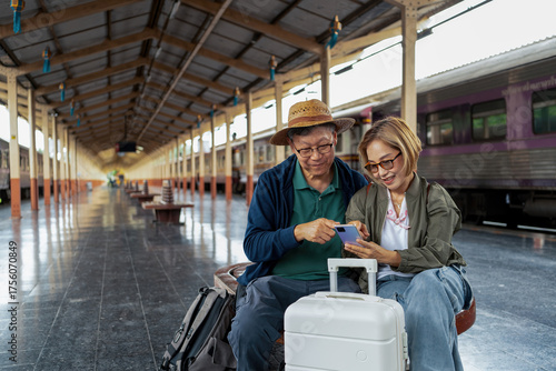 Happy Asian senior boarding a train at the station