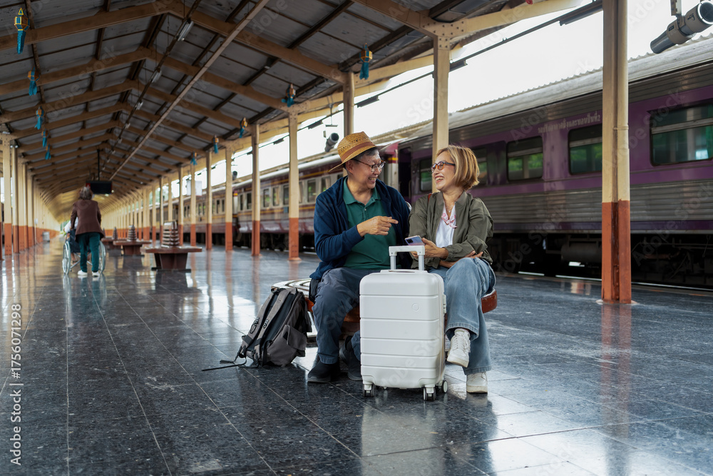 Obraz premium Happy Asian senior boarding a train at the station