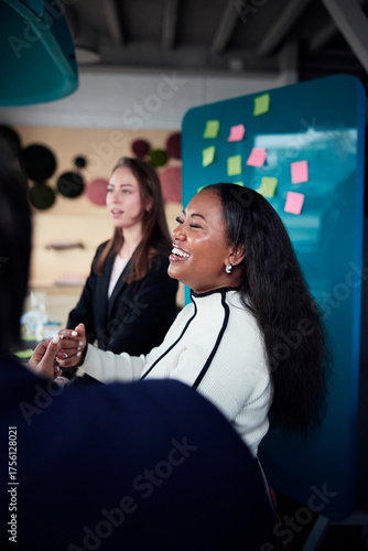 Happy businesswoman with long hair discussing in team meeting at office