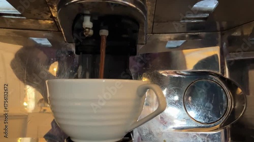 Pouring milk and coffee in a tea cup.