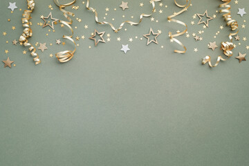 New Year, Christmas or birthday festive background top view. Celebration composition with golden confetti stars and serpentine party streamers.