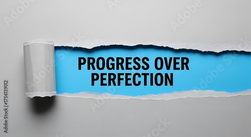 Torn paper revealing the motivational phrase progress over perfection on a blue background