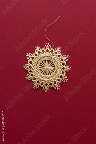 Snowflakes are made of straw on a red background. Christmas decor. Straw star. Top view. Straw weaving. Lutsk, Ukraine
