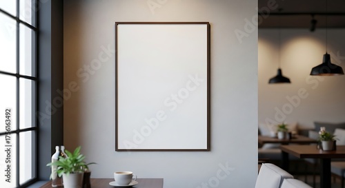 Blank white picture frame on a light wall in a modern cafe interior with natural light.