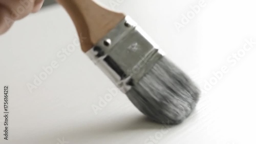 Close up of a paintbrush against white surface ready for creative use