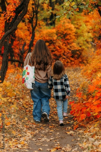 Family Walking With Pet Golden Retriever Dog Along Autumn Woodland Path Together