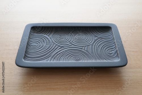 Rectangular dark gray tray with embossed swirling pattern