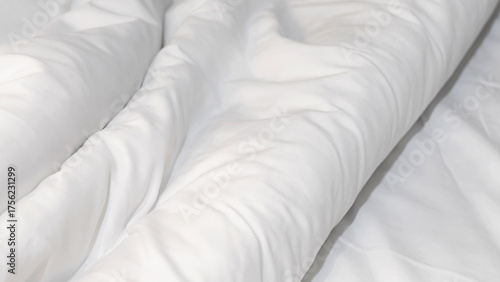 Close up soft white wrinkled duvet bed sheet texture, minimal background for comfort, cleanliness, and relaxation concept in bedroom or hotel interior