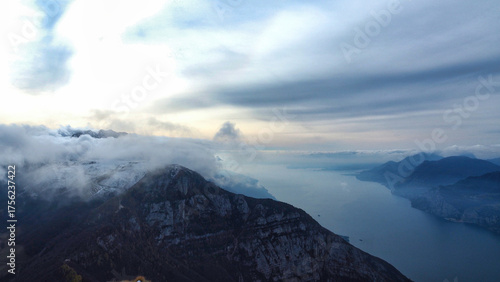 Φωτογραφία Winter landscape at high altitude with peaks among the clouds and Lake Garda fro