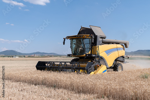 Una cosechadora en pleno trabajo segando cereal en una finca durante el verano