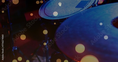 Showcasing drum kit bathing in warm bokeh lights on dim stage, with tom drum, cymbal, stands