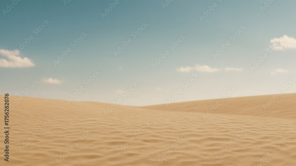 Naklejka premium A vast, tranquil desert landscape featuring gentle sand dunes under a clear blue sky with a few scattered clouds.