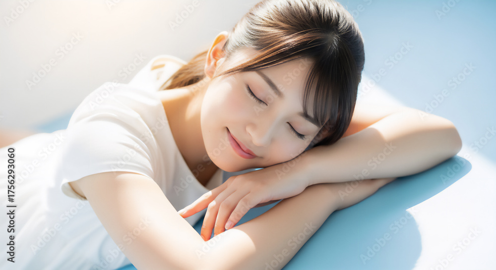 Fototapeta premium 爽やかな水色背景の下で微笑む女性のポートレート