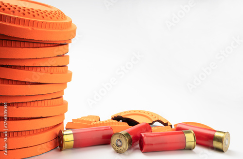 Flying clay pigeon target with shot gun bullet shell on white background , Gun shooting game