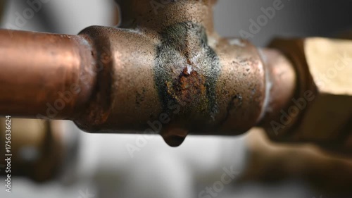 Close-up of a Copper Pipe Joint with Rust and Water Leak Details