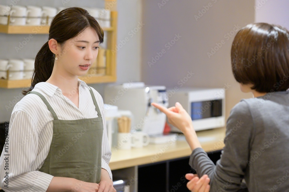 Fototapeta premium 利用客のクレーム対応をするカフェの女性店員