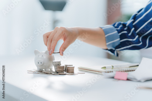 Investing in Savings: A person is diligently saving and investing a coin into a piggy bank, symbolizing financial growth and planning for the future.