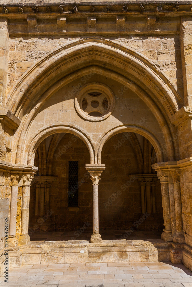 Obraz premium A sunlit stone archway with a central column and circular window frames