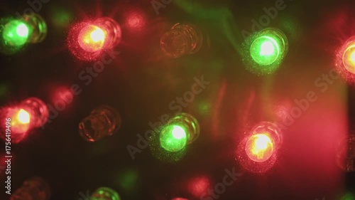 Macro of flashing RGB LED lights on a panel showing pulsing blue red and green diodes with sparkly dust particles creating a dynamic colorful and abstract electronic light show.