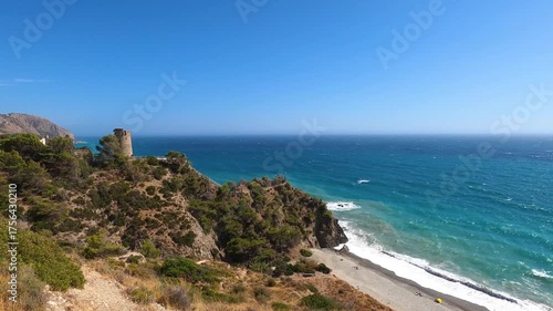 Panoramic view of the Mediterranean Sea with turquoise water, coastal hills, and clear blue sky in La Herradura, Andalusia, Southern Spain.