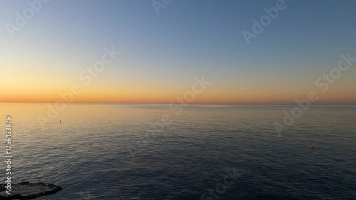 Sunrise over the sea in Rincon de la Victoria, Malaga, Spain, with golden light reflecting on calm waves along the coast.