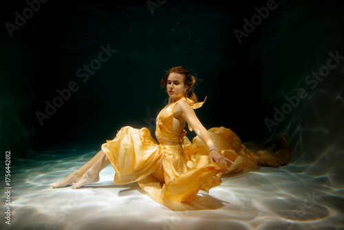 An Ethereal Underwater Dance Taking Place in a Beautiful Yellow Gown and Flowing Elegantly