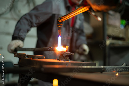 Workers of the blacksmith's workshop heat the metal part to red, for further forging and giving the desired shape. High quality photo