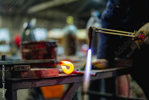 Workers of the blacksmith's workshop heat the metal part to red, for further forging and giving the desired shape. High quality photo
