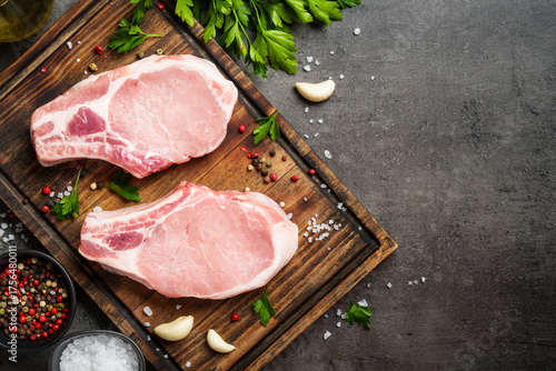 Raw pork steak. Fresh meat on cutting board with spices.