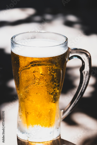 50 cl pint of beer served on wooden surface. Cold beer glass on wooden table. Refreshing golden beer in glass on wooden table. Full glass of lager beer on wooden table.