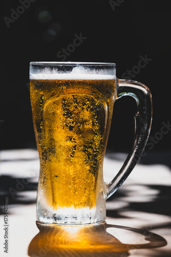 50 cl pint of beer served on wooden surface. Cold beer glass on wooden table. Refreshing golden beer in glass on wooden table. Full glass of lager beer on wooden table.