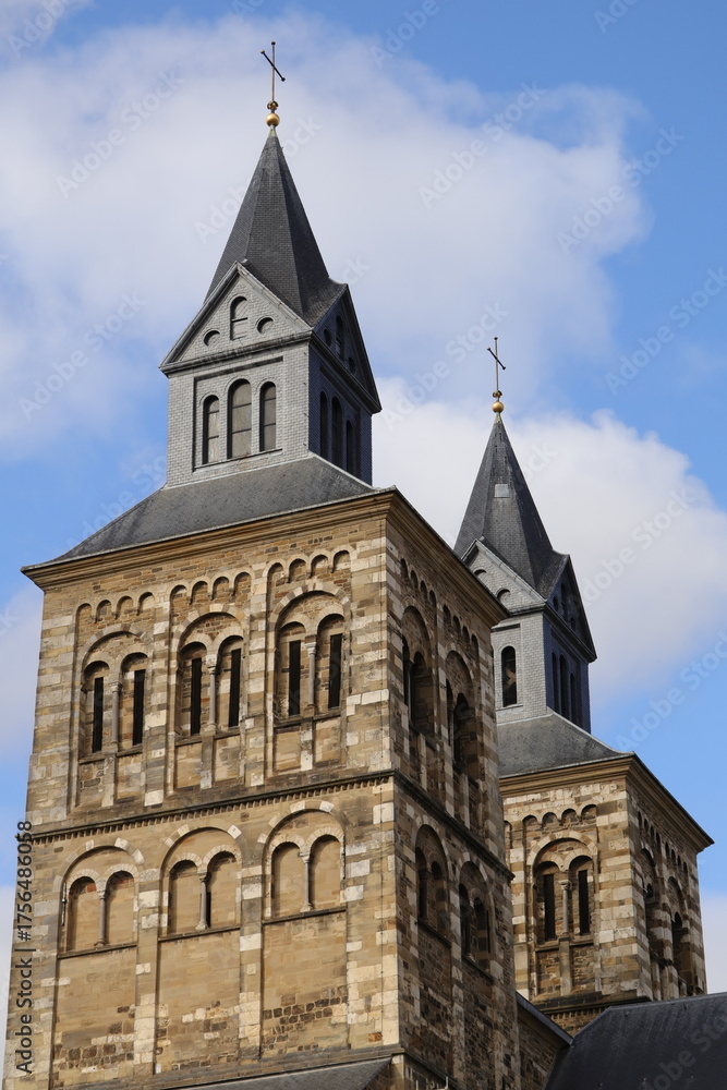Fototapeta premium Maastricht Cathedral Twin Towers in Autumn Light: Historic Brick Church with Sloped Steeples