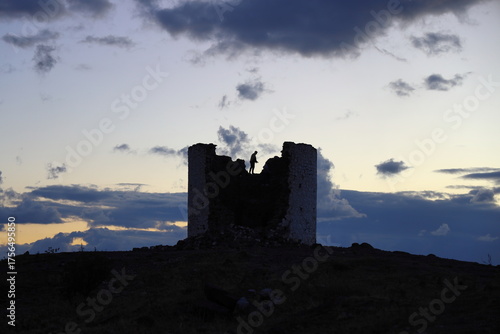 The abandoned historical windmills that are synonymous with the famous holiday resort of Bodrum.	With the silhouette of a man standing on the ruined mill in backlight.
