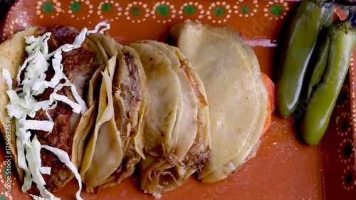 Hands preparing delicious traditional mexican steamed tacos with cabbage and chilis on a clay plate