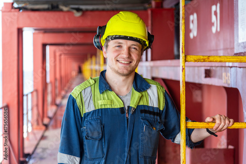 Portrait of the young officer on deck of a large cargo container ship.