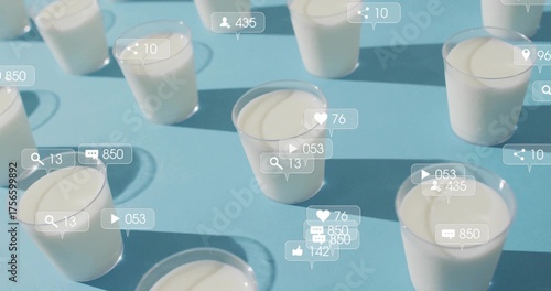 Social media icons hovering above clear plastic cups with white yogurt on blue table, with counters